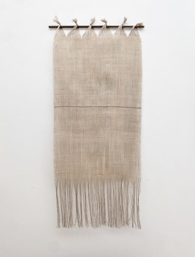 The Distant Horizon by Sundance Studio is a minimalist wall hanging featuring fine beige threads tied to a top rod, forming a loose weave that tapers into fringes on a plain white backdrop, evoking the wide open spaces of Yuraygir National Park.