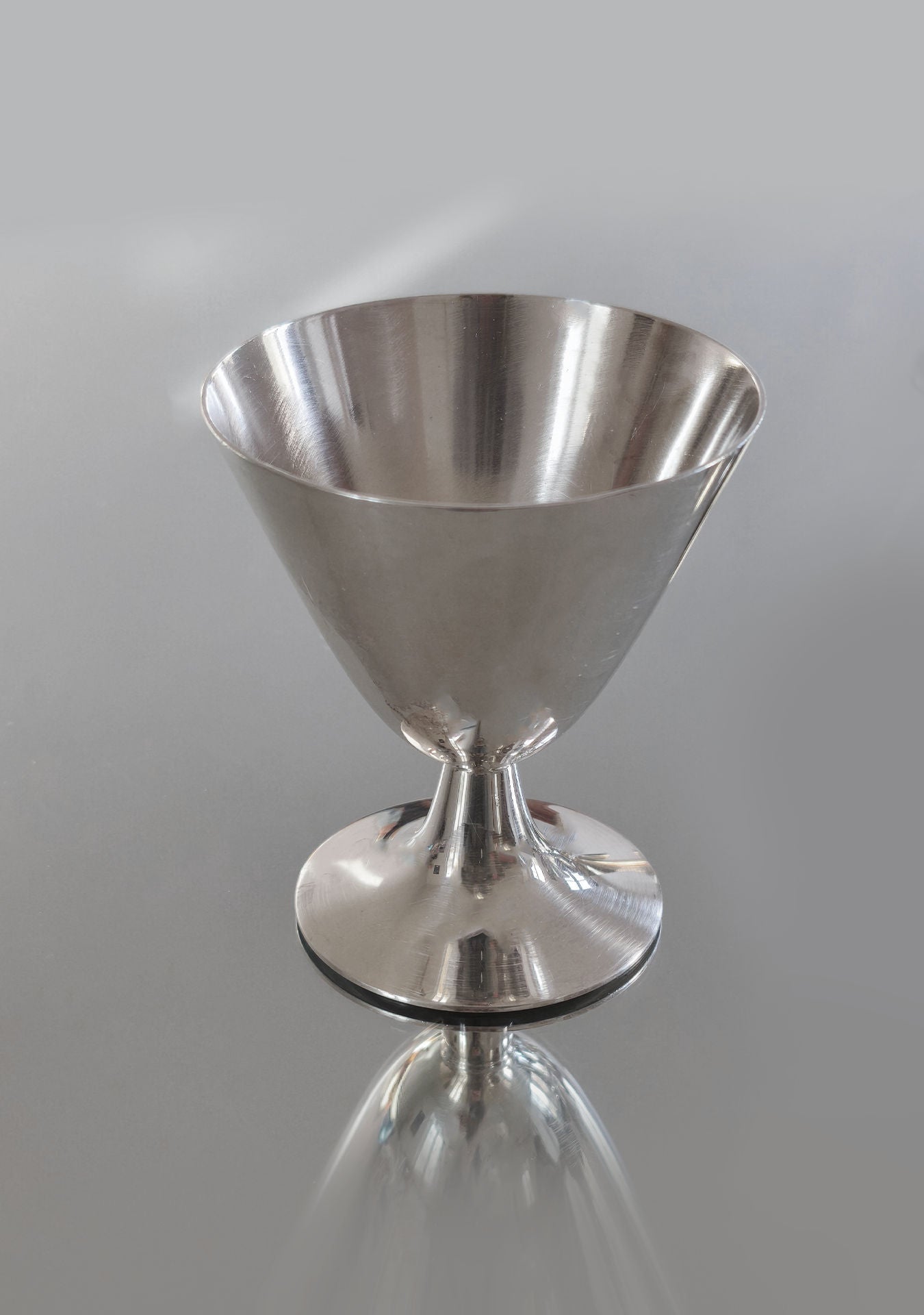 The Set of 6 Christofle Cups by Les Objoies offers timeless luxury with their sleek, silver metallic finish and conical design. Their smooth surfaces brilliantly reflect light, perfect for adding elegance to any neutral gray decor.