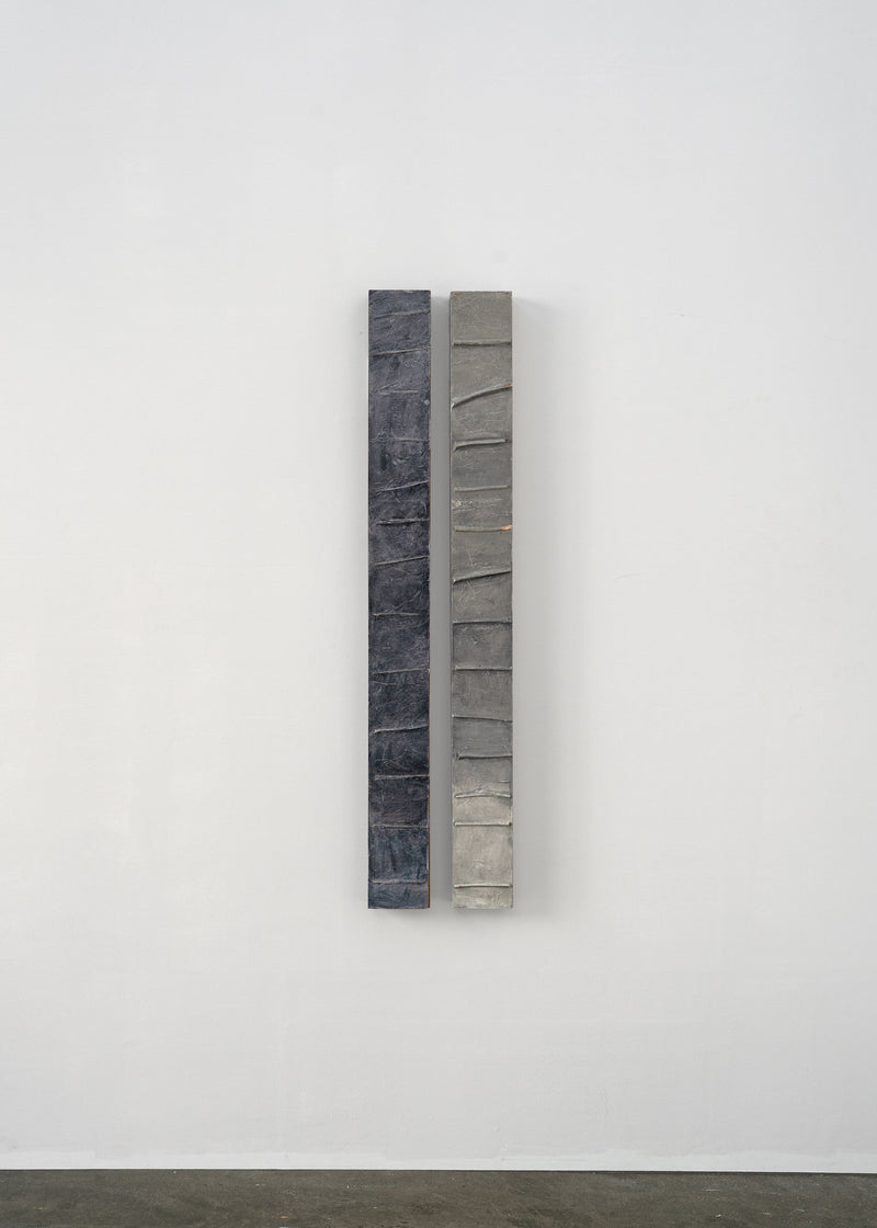 Two vertical slate sculptural columns with segmented surface textures