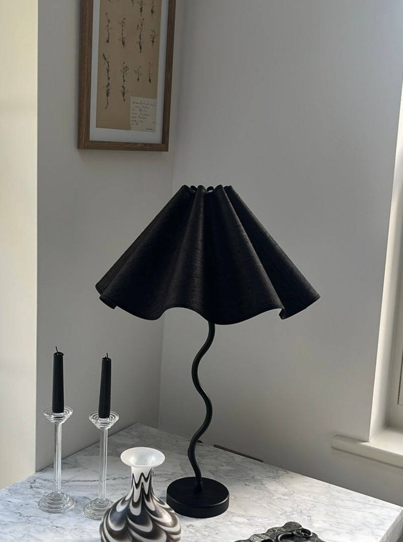 Alt text: The Maud Vaughan Wiggle Lamp, a stylish and modern lighting fixture with a unique wavy design, perfect for adding a touch of elegance to any room