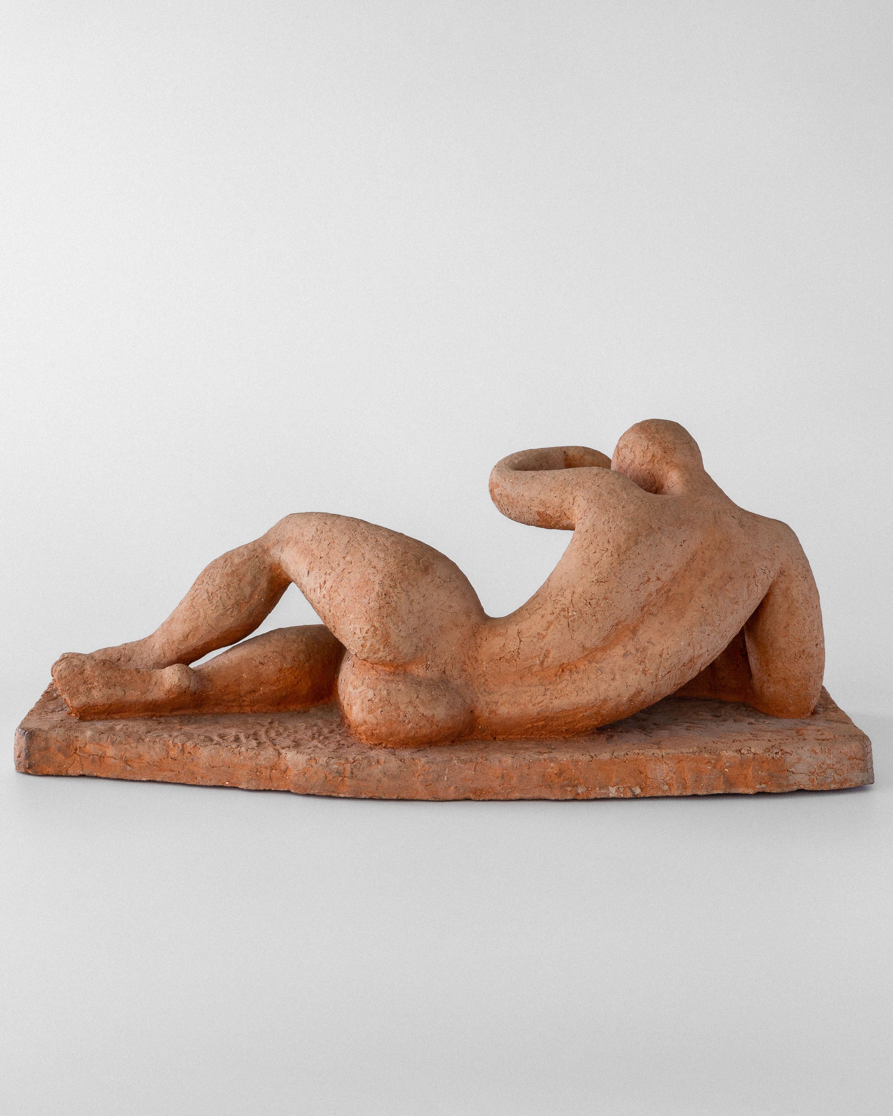 The 1950s Swedish modernist terracotta sculpture by Bengt Amundin for Spigel features a reclining nude in a minimalist, abstract style. The unglazed figure has smooth, rounded forms and rests gracefully on a simple rectangular base.