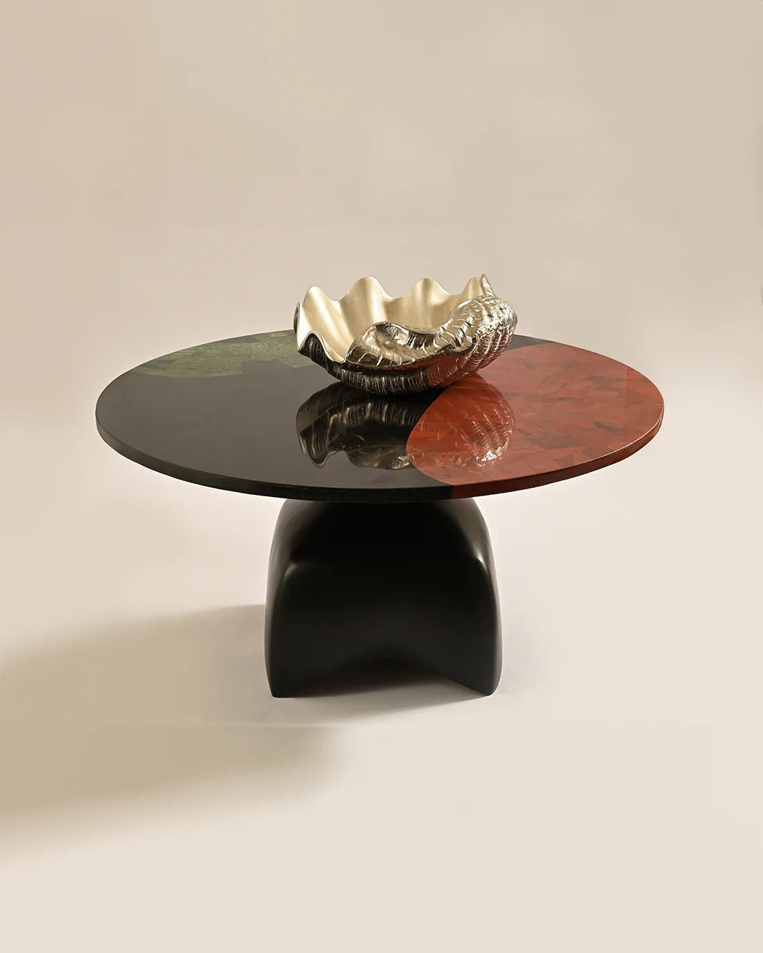 The LMNOH Jasper Coffee Table features a glossy, segmented surface in black, green, and reddish hues. It includes a sculptural ceramic bowl with an undulating design and rests on a sleek black casted aluminum base, seamlessly blending artistry and contemporary elegance.