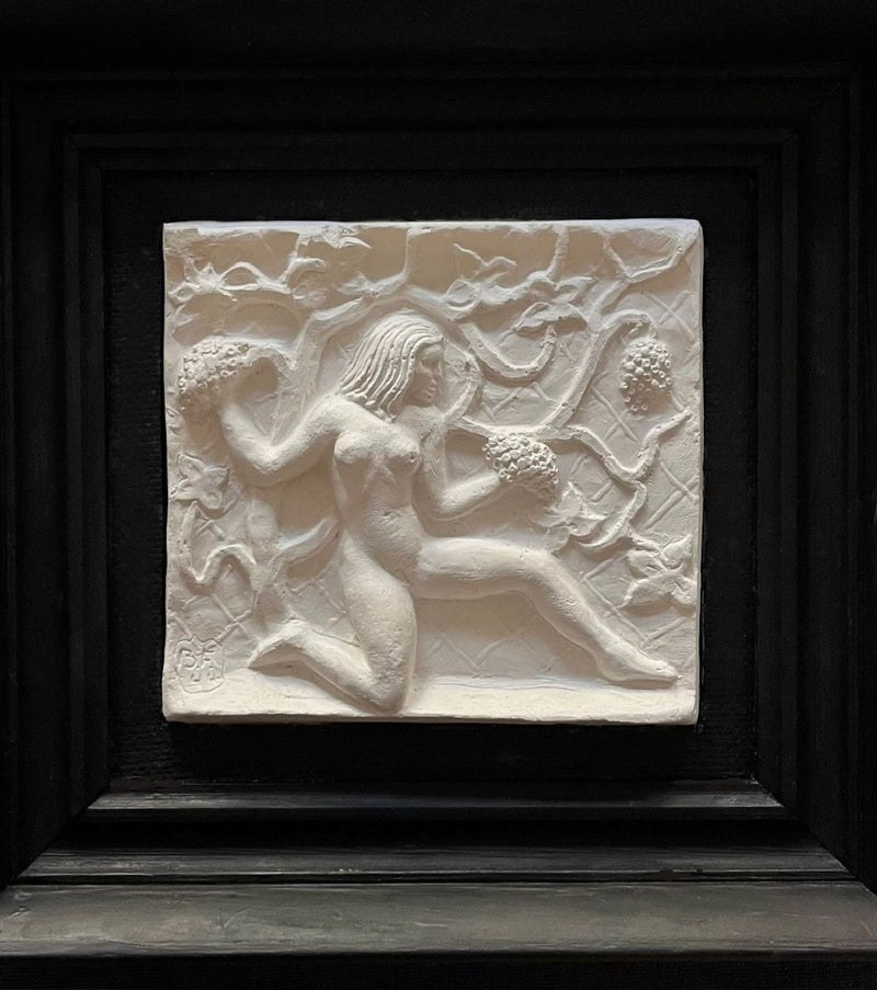 The Midcentury Plaster Relief by Bo Fjaestad from Médecine showcases a nude figure kneeling in a tropical garden with floral and vine motifs. Set in a dark square frame, the artwork's light colors vividly contrast against it.
