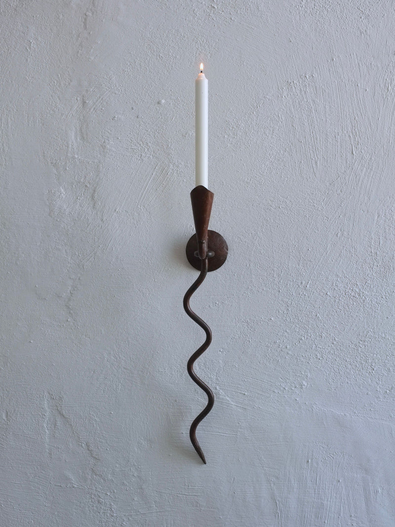 Wall-mounted wrought iron candle holder with serpentine design