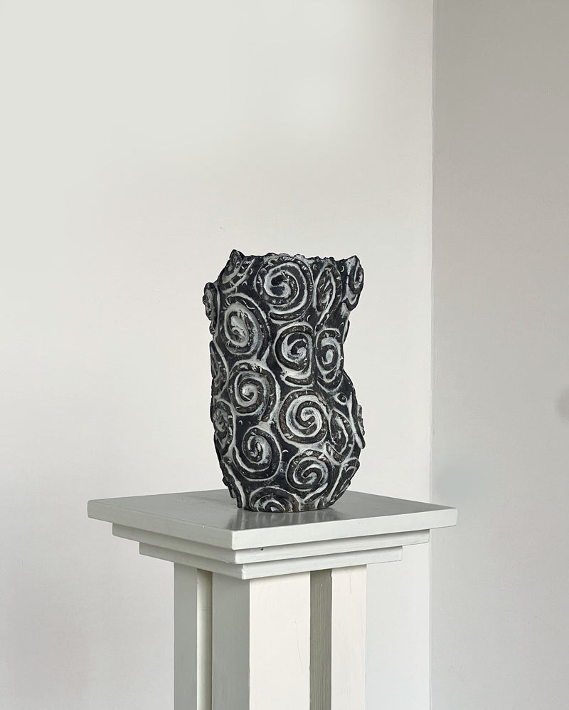 Dark ceramic vase with raised spiral pattern detail view