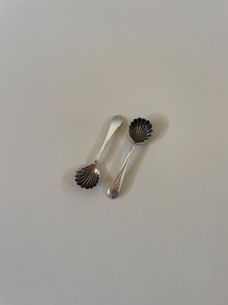 Antique silver Mappin and Webb salt cellars featuring ornate floral motifs and scalloped edges