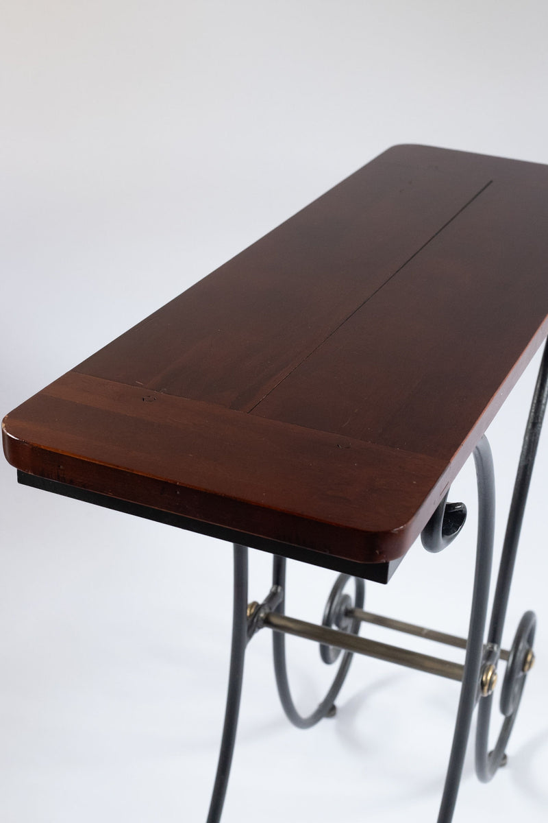 Close-up detail of walnut wood tabletop with iron frame legs