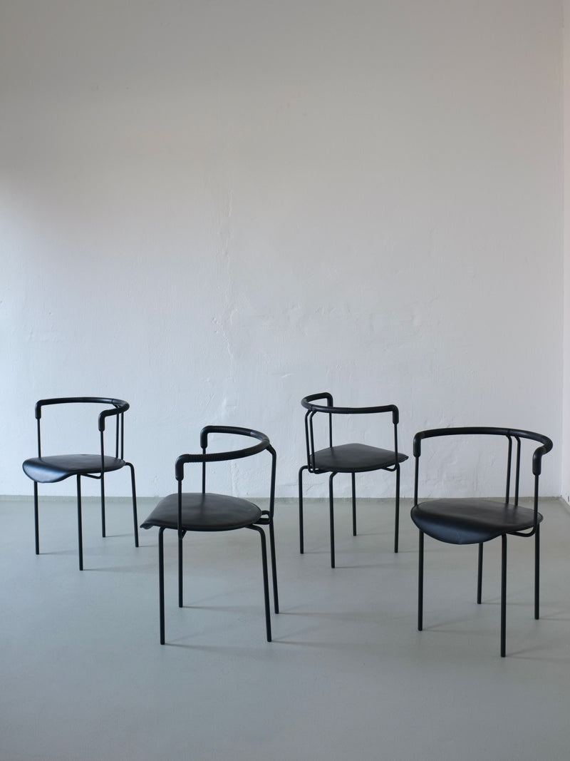 Four black leather postmodern armchairs with curved backrests