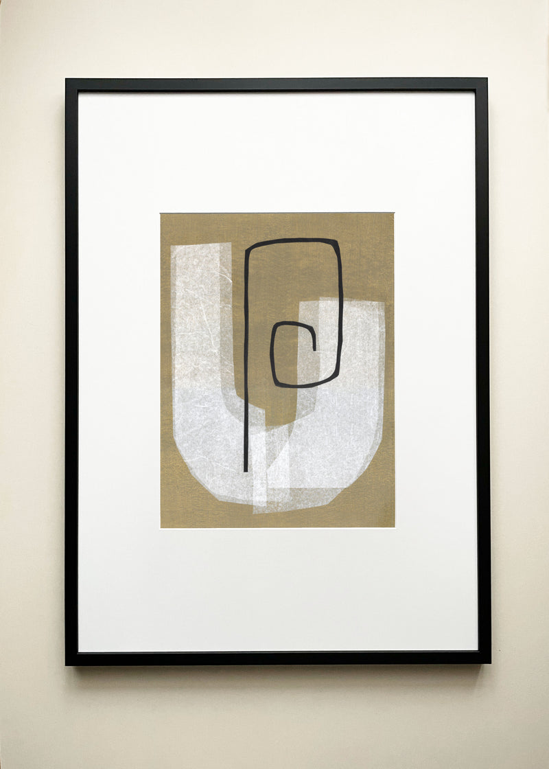 The "Purpose" Art Collage by Julita Elbe is a minimalist, framed abstract piece featuring white and beige geometric shapes with a bold black spiral on tan, inspired by paper collage and mixed media art, displayed against a neutral wall.