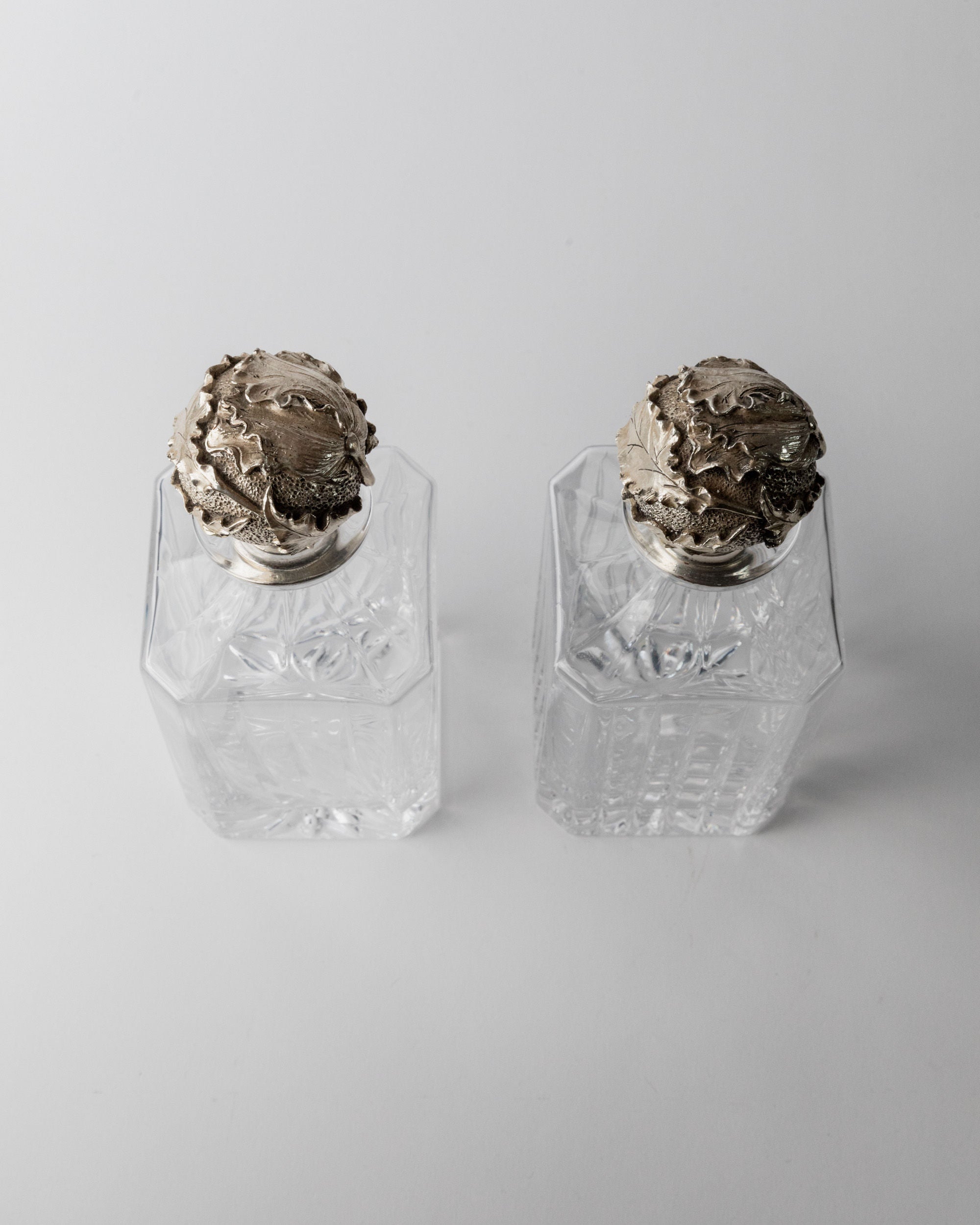 Detail of ornate silver tops on vintage Italian glass decanters