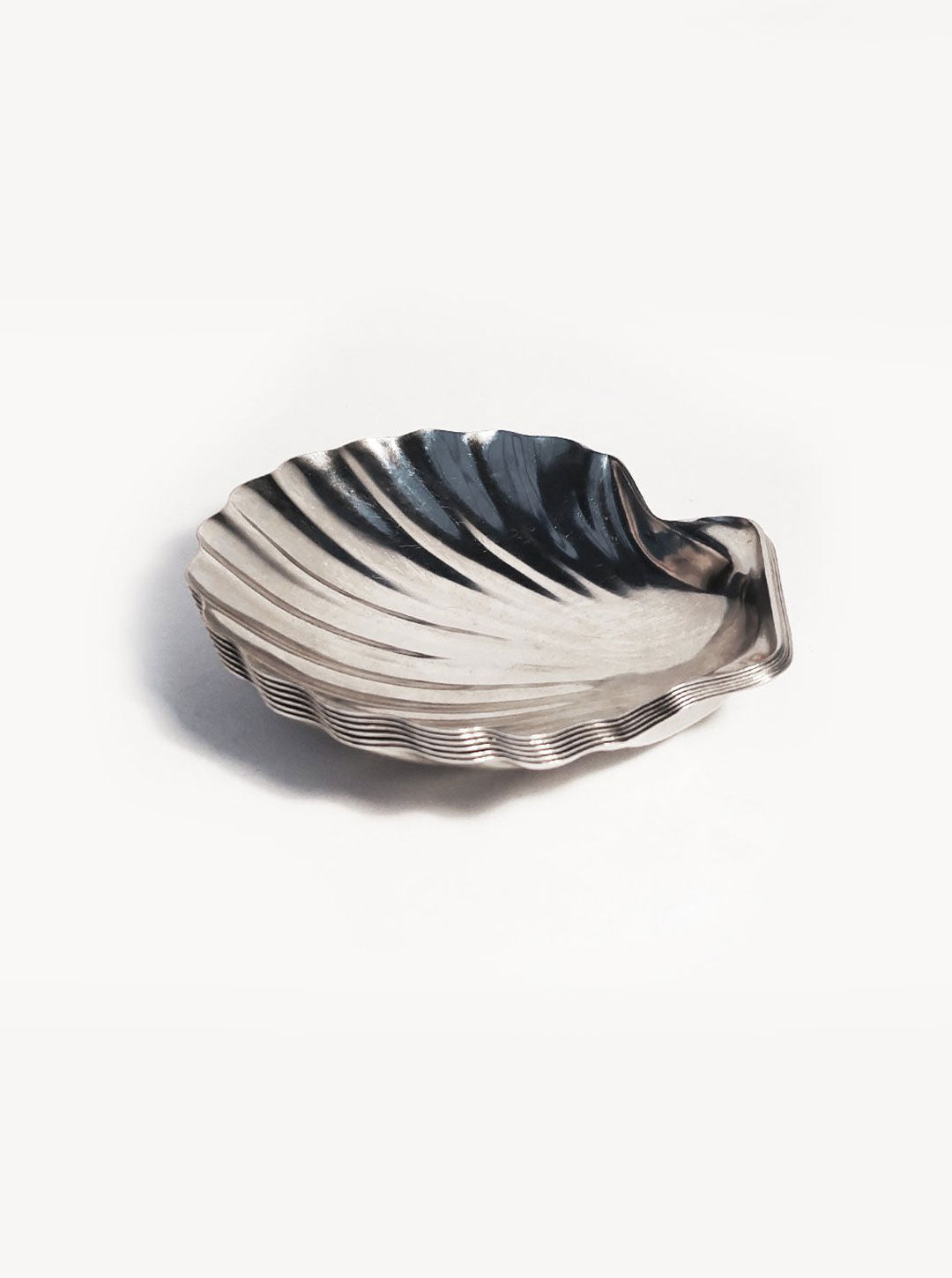 A **Set of 6 Small Shell Dishes** designed to resemble scallop shells, featuring intricately curved ridges and a textured surface, is placed against a plain, light background. The dishes have a reflective, shiny finish and appear to be slightly elevated from the surface. This exquisite set is offered by **Les Objoies**.