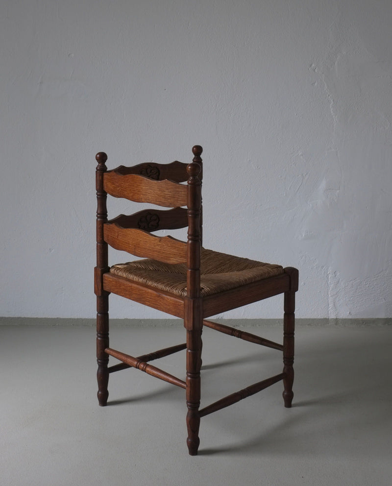 Carved oak corner chair with woven rush seat, side view