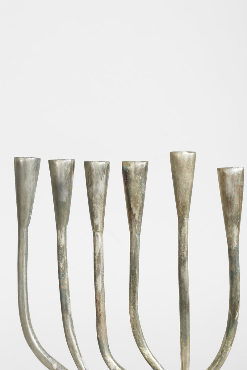 Brutalist menorah with six curved brass candleholders detail view
