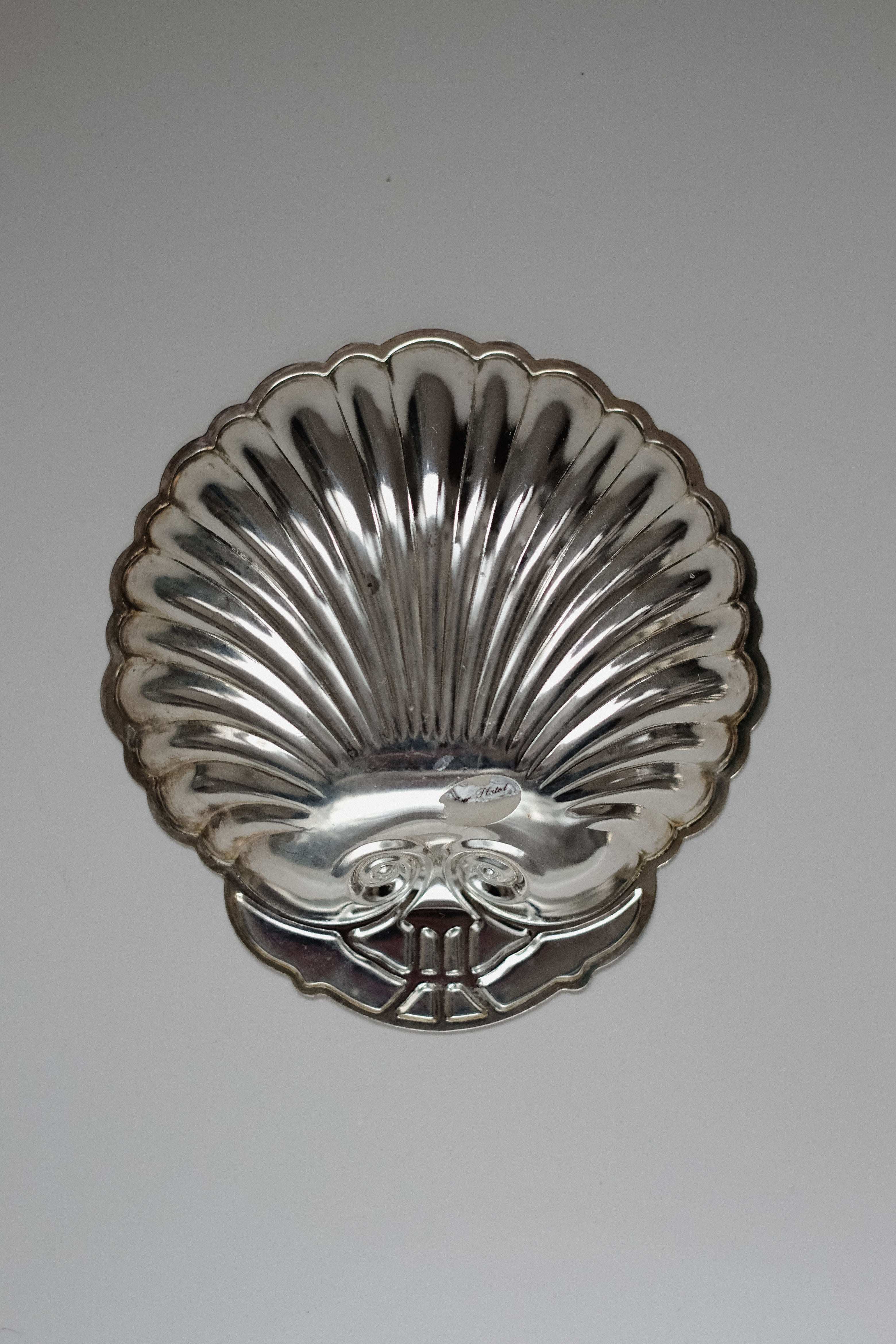 The Set of 2 Silver-plated Shell Trays by septembre studios features vintage-style scallop designs with shiny, reflective surfaces and ornate detailing, perfect for enhancing dining experiences.