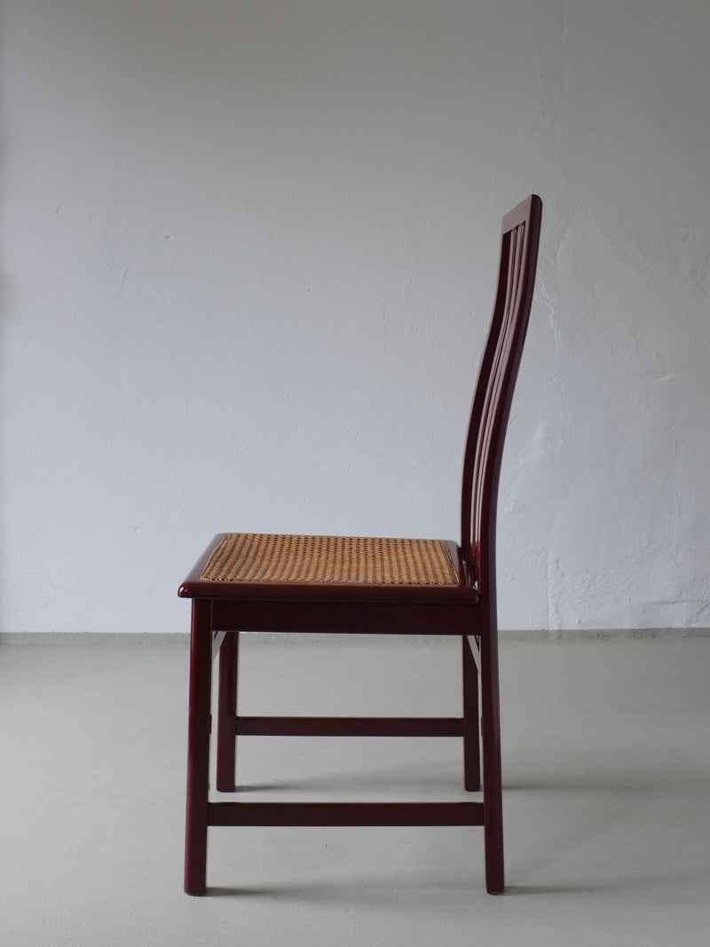 Side profile view of glossy wine red cane seat dining chair 1970s