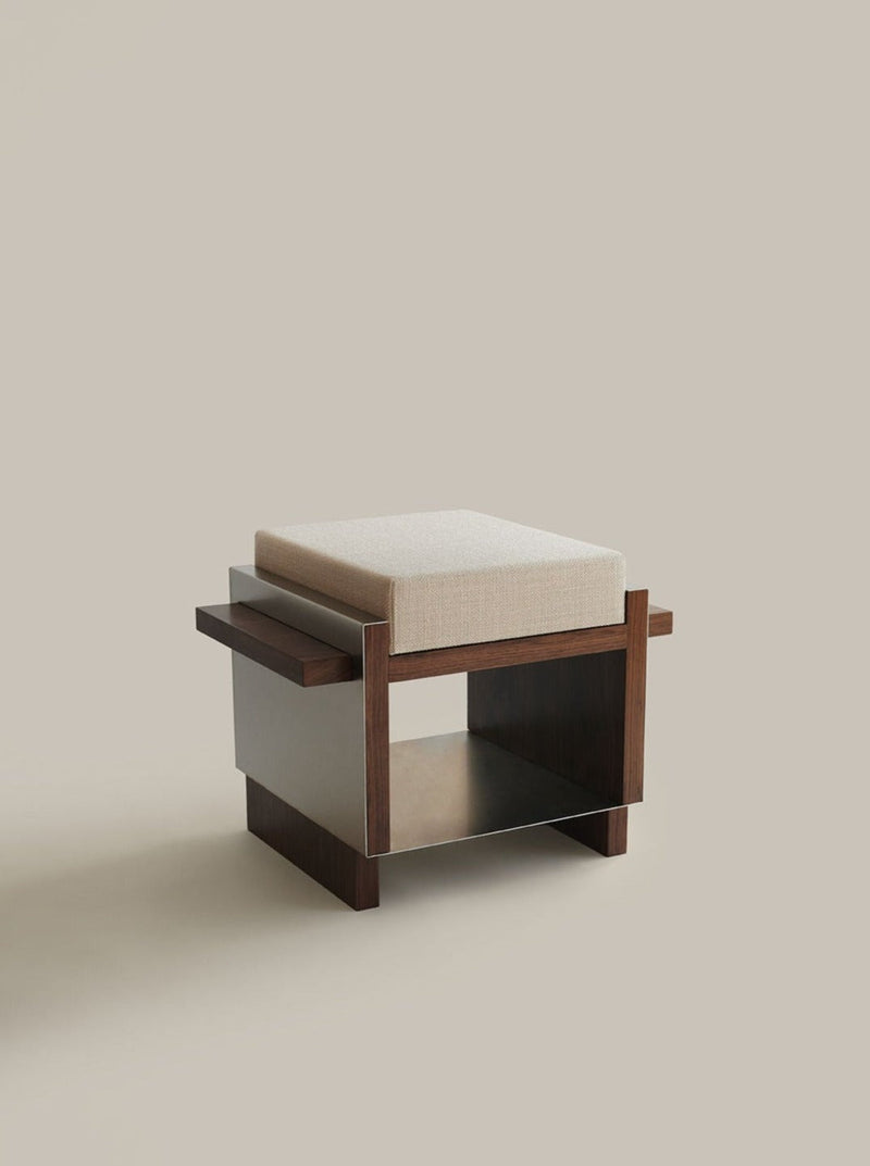 The B1 single stool by Sofia De=Francesco is a modern walnut piece with a light beige cushion, clean lines, a rectangular base with open sides and shelf—premium artisanal design set against a plain, light backdrop.