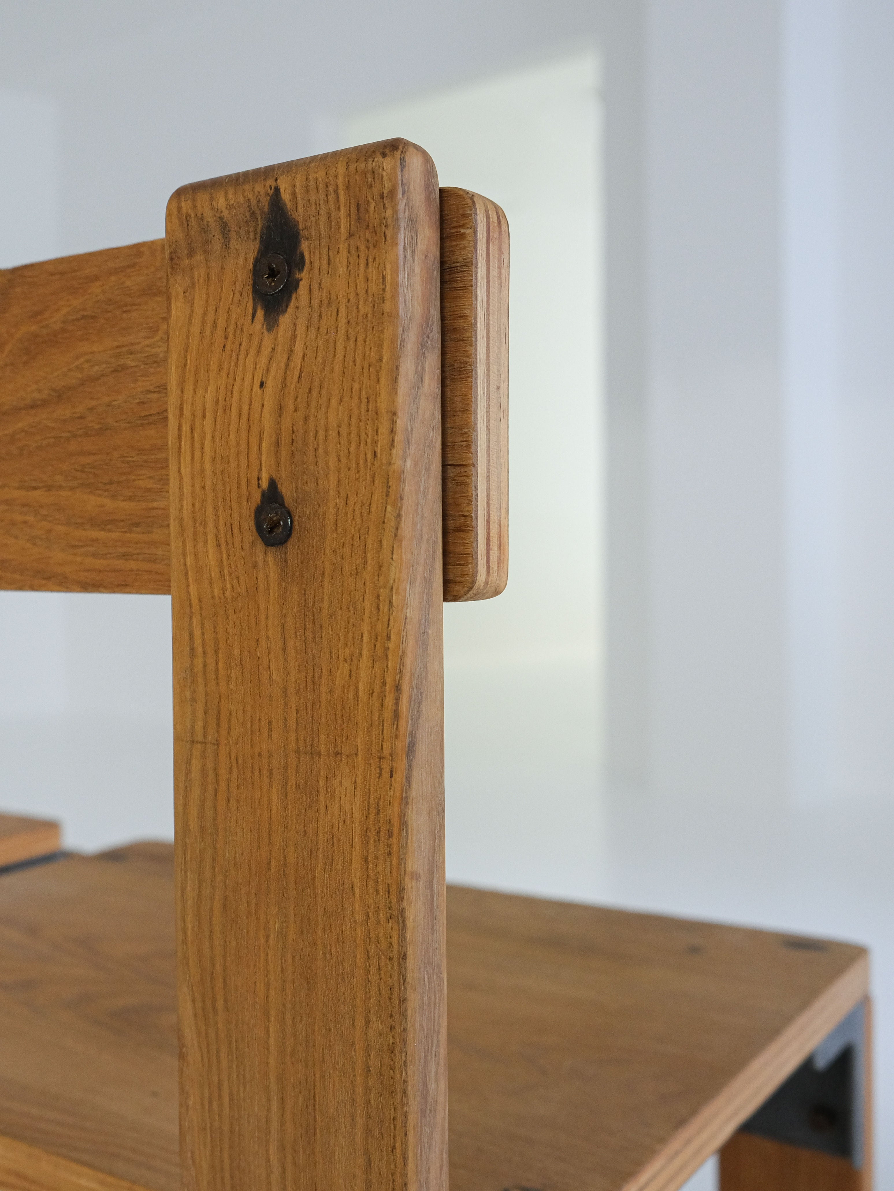 Close-up of a "Les Carats“ Dining Chair by George Candilis and Anja Blomstedt 1970s, crafted from oak plywood with a minimalist design. The chair's clean lines and visible joinery highlight its natural texture for a modern-rustic aesthetic, with a softly blurred background. Brand: antibeige.