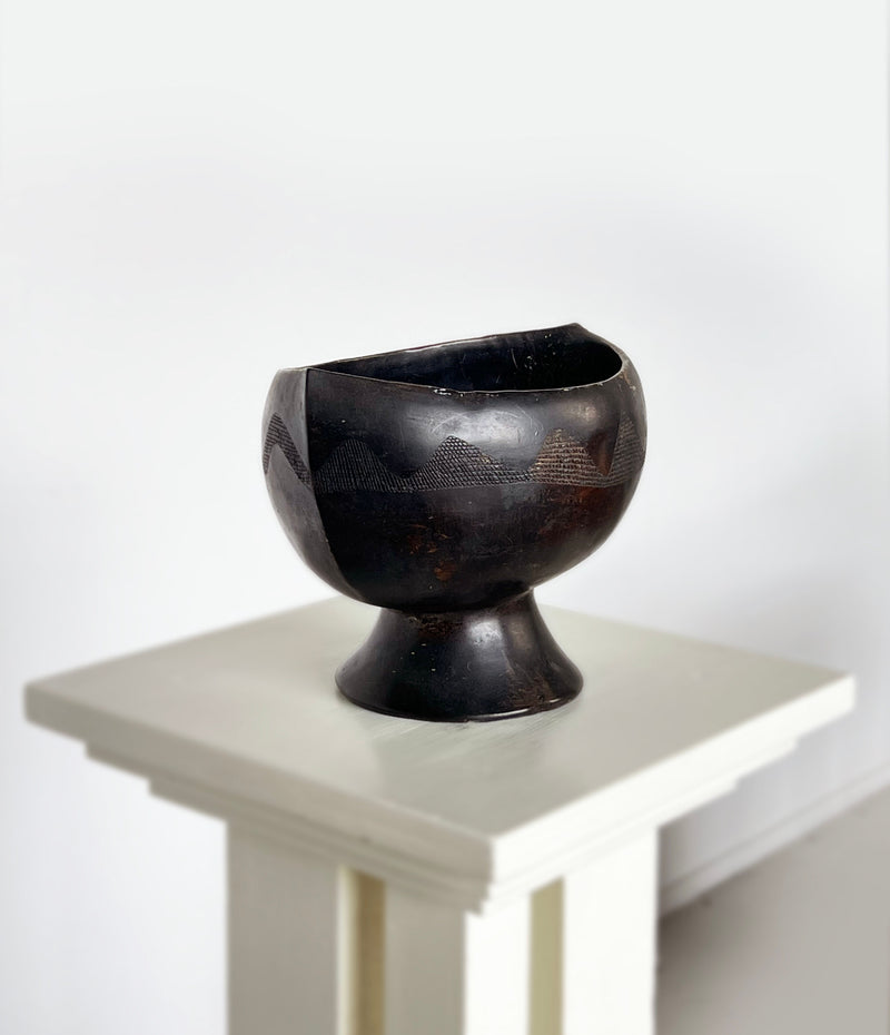 Dark ebony carved dish with geometric patterns on pedestal base