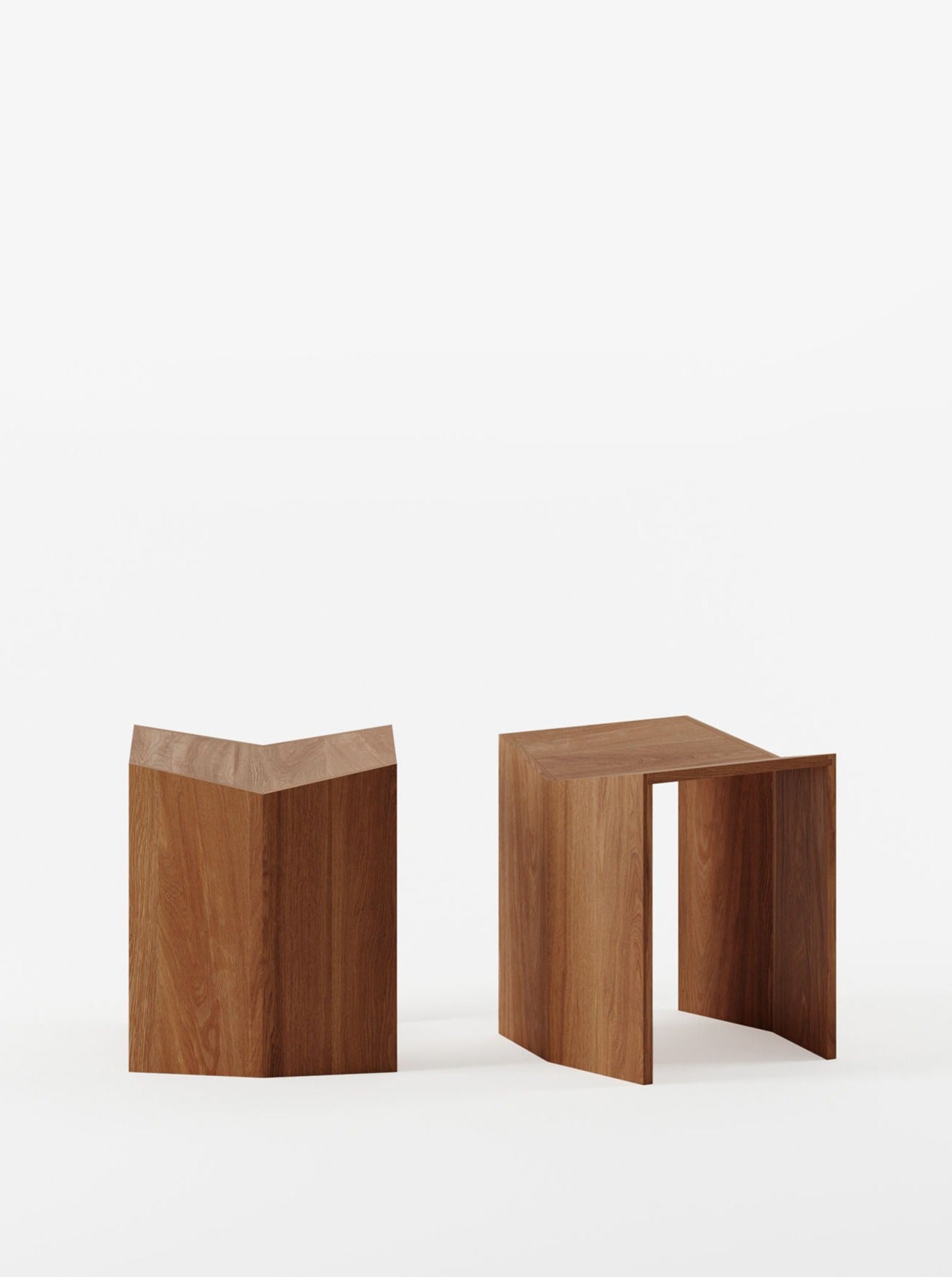 Two Athens Stools in Iroko by Lemon with geometric designs on a plain white background. One stool has a simple cube shape, and the other features a U-shaped cutout regarded as an Athens stool.