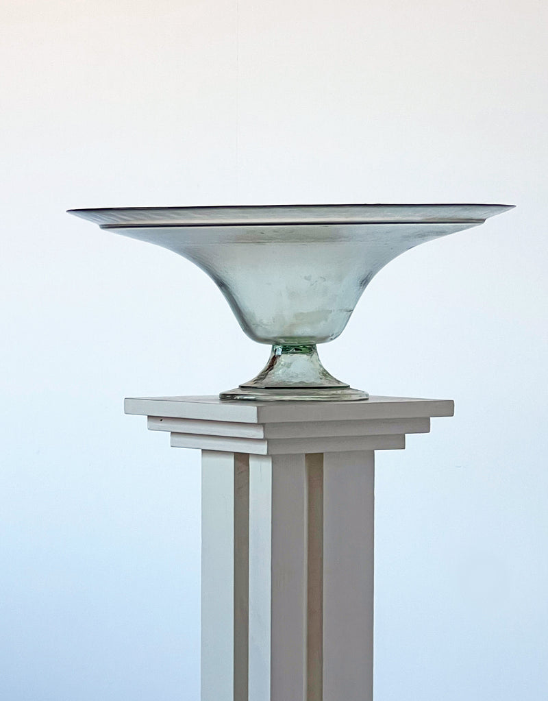 Translucent glass pedestal bowl with wide rim on white column stand