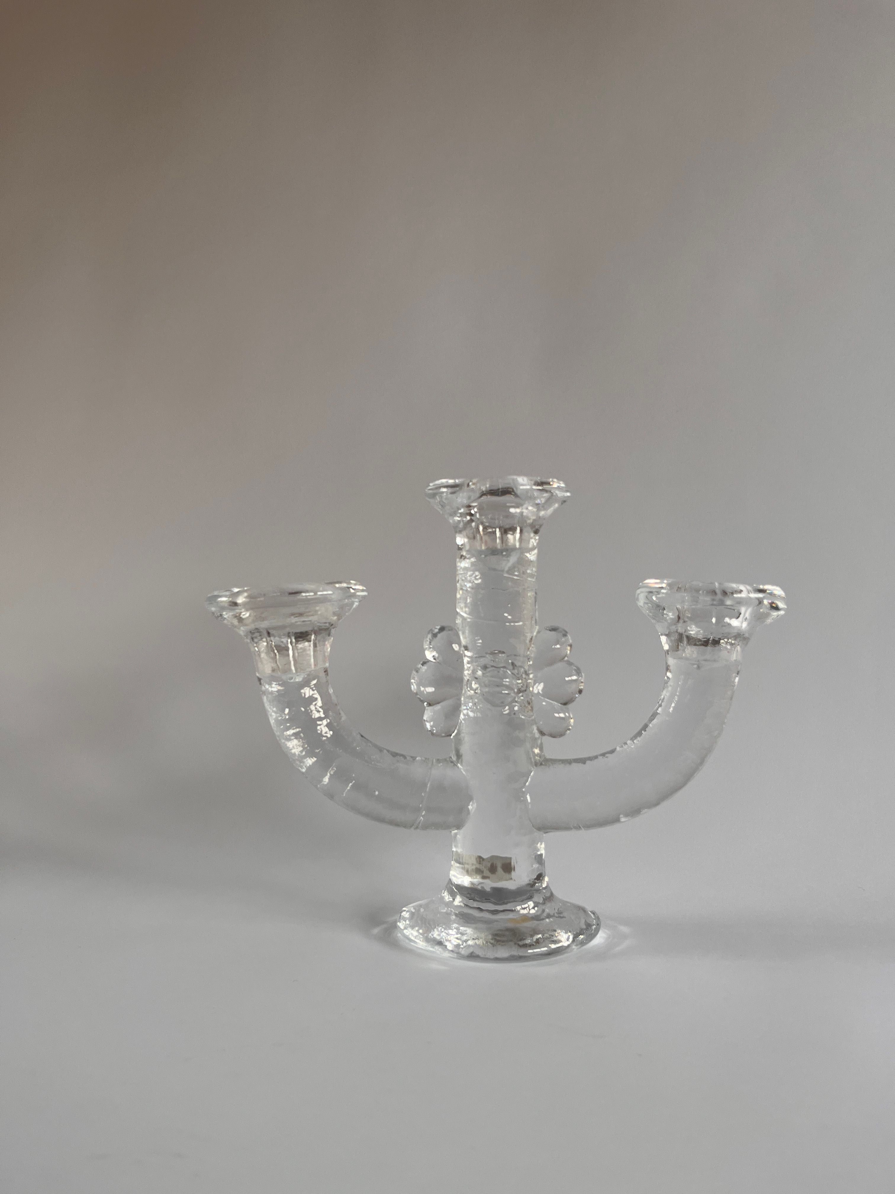 This Swedish Glass Candelabra by Staffan Gellerstedt for Maud Vaughan is a vintage creation featuring three elegantly upward-curving arms and a rounded base, embodying an elegant and symmetrical design.