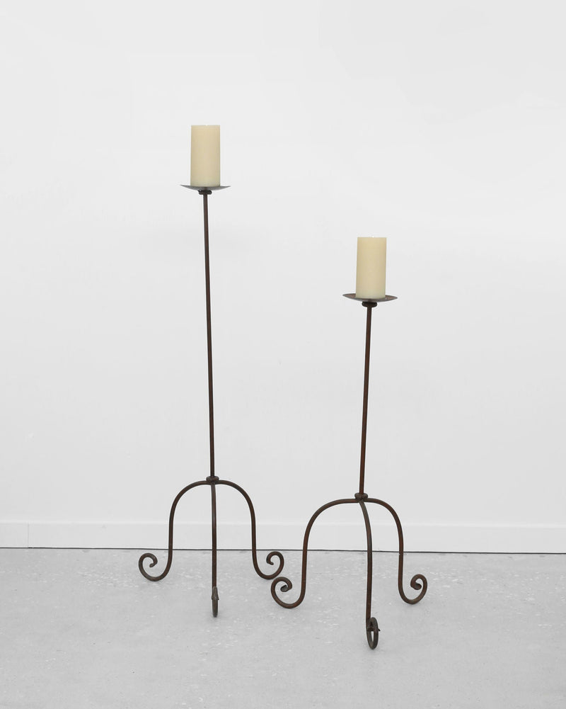 Set of two wrought iron floor candleholders with scrolled legs
