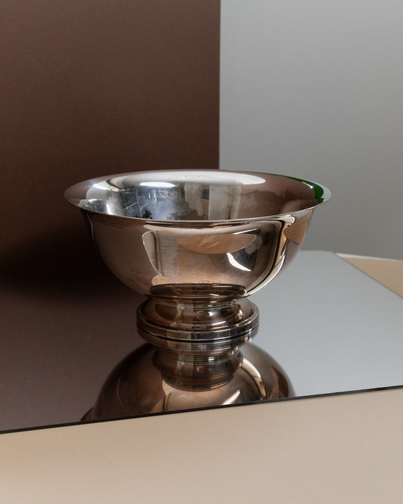 Polished silverplated bowl reflecting on glass surface detail