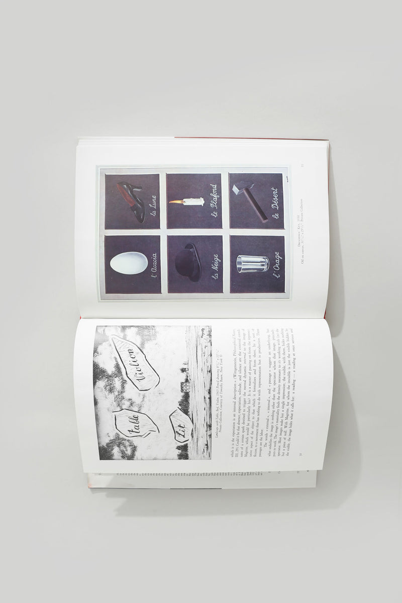 Open Magritte art book showing surrealist object illustrations