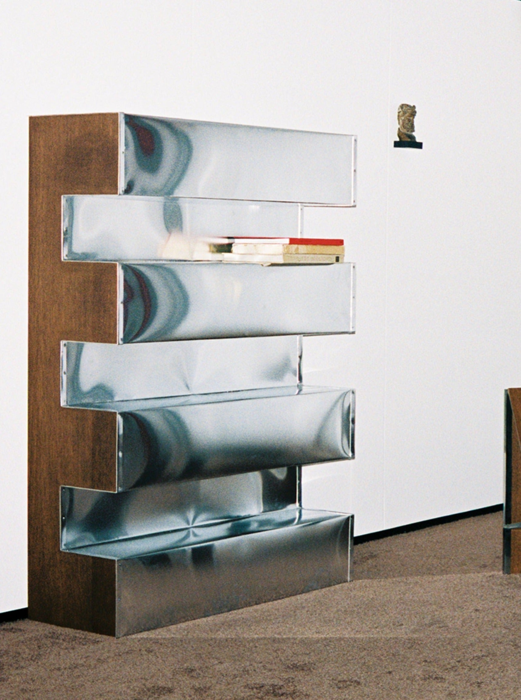 Aluminum and plywood bookshelf with adjustable shelving and sleek design