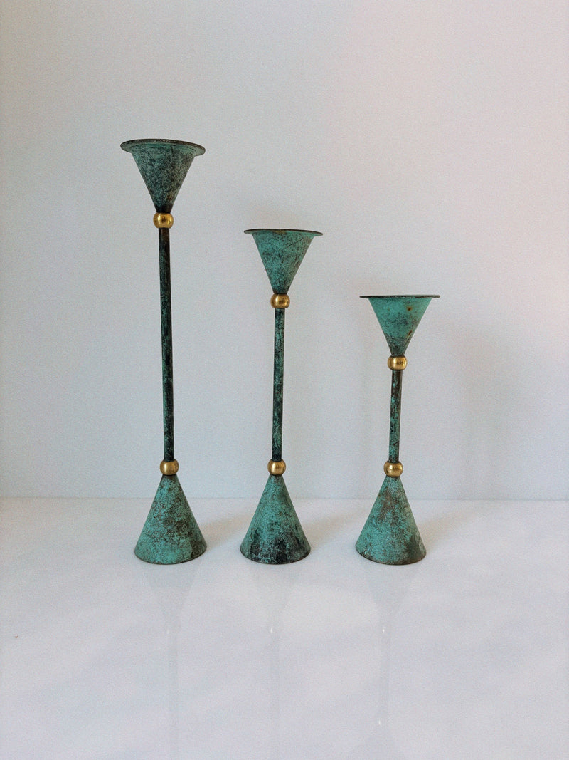 Set of three verdigris bronze candlesticks varying heights