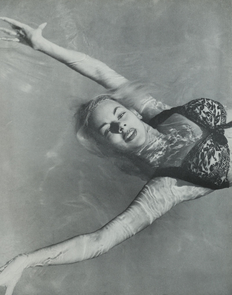 Woman laughing while reading Photography is a Language book in water