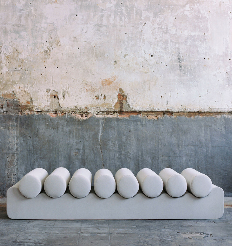 Modern white velvet daybed with cylindrical cushions detail