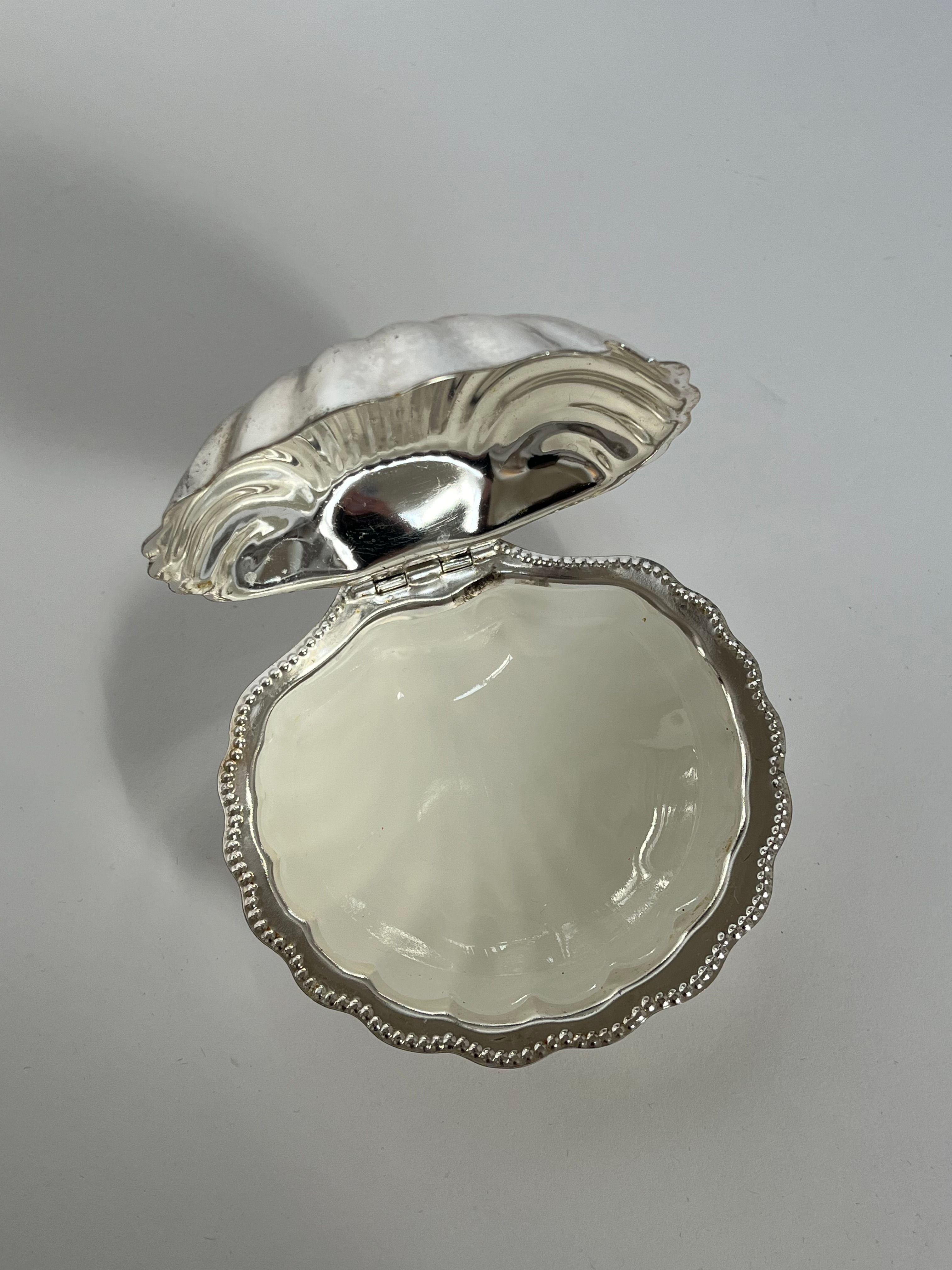 The Shell Shaped Butter Dish by septembre studios features a vintage brass design with an open top that reveals a smooth, pearly interior, set against a plain background.