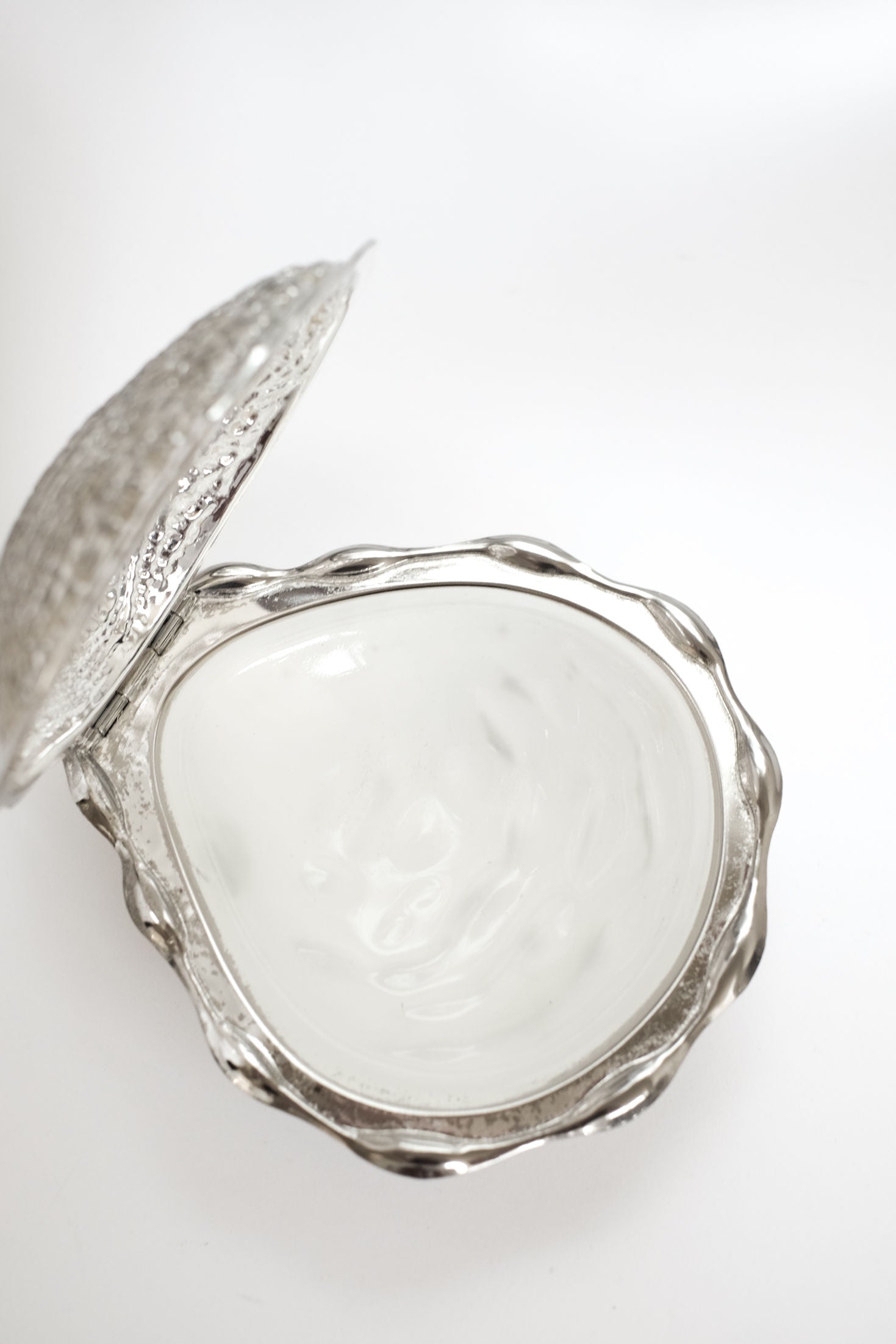 The Shell Butter Dish by septembre studios is a vintage-style, silver scallop shell dish with a hinged lid, revealing a smooth, shiny interior, shown against a plain white background.