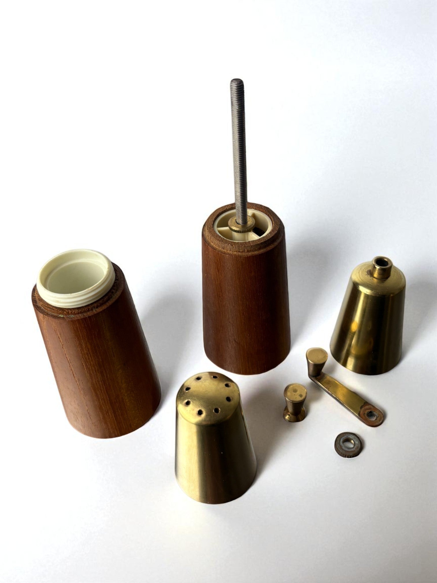 Disassembled rosewood and brass salt pepper mill components