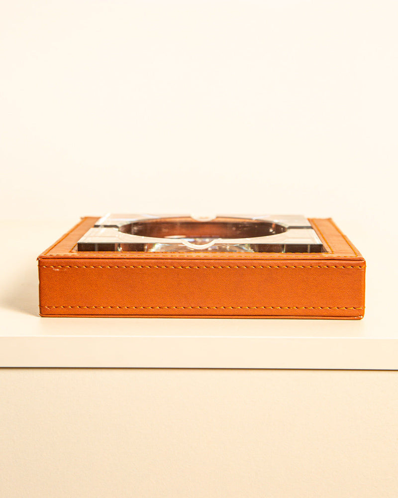 The Square Glass and Leather Ashtray 90s by Treaptyque features a brown base and sits on a light surface, its luxurious design echoing timeless refinement against a simple background.