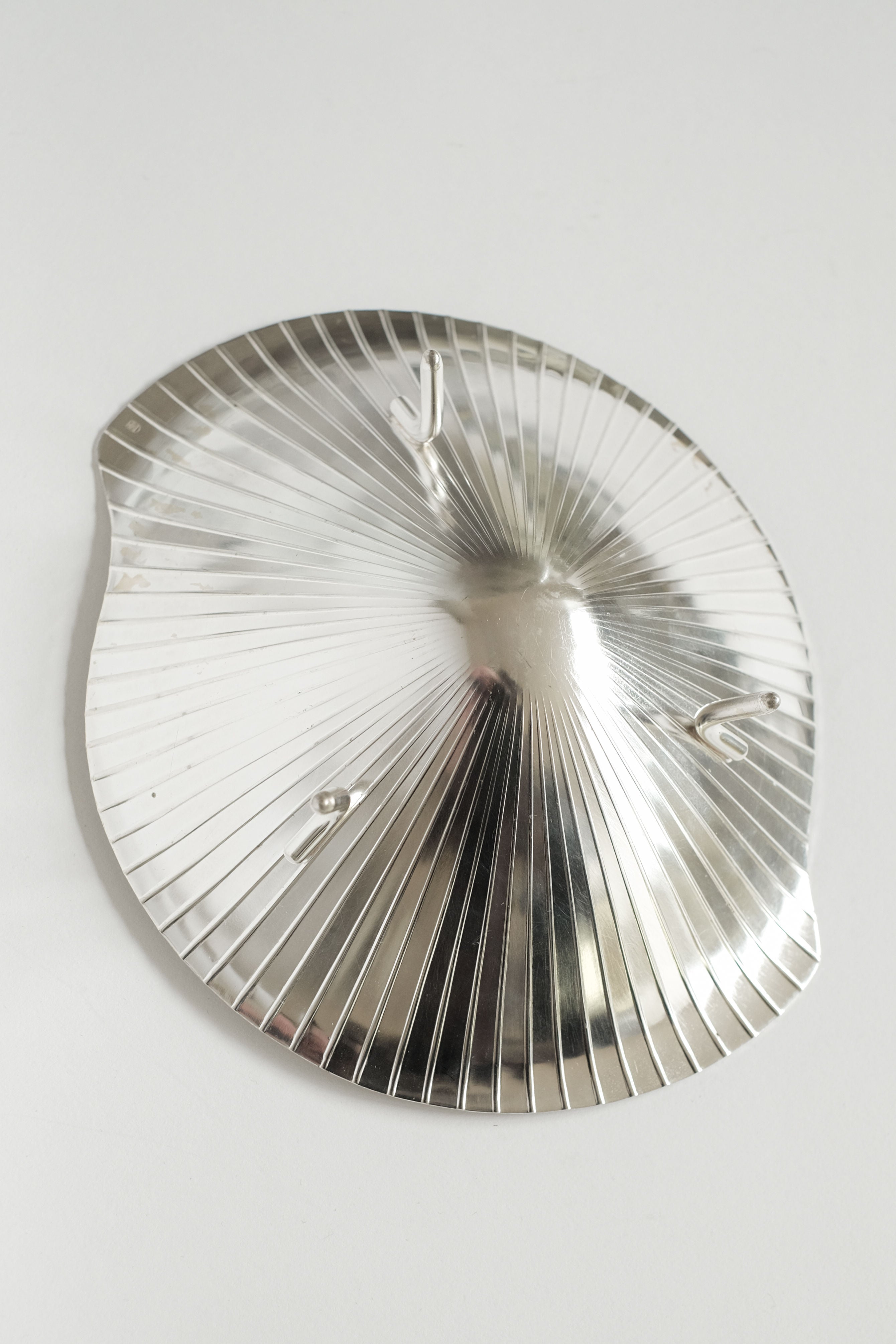 The Silverplated Shell Dish WMF by septembre studios is a vintage-inspired, ribbed, silverplated wall hook with three hooks on a plain white background.