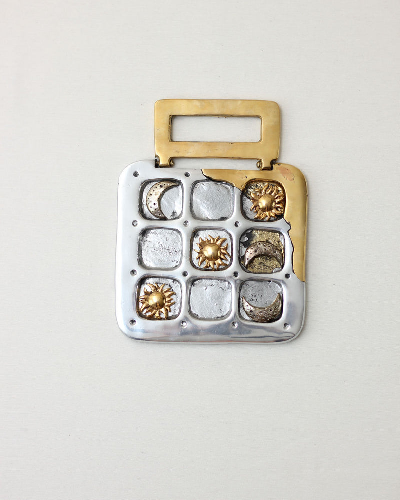 Brutalist tic-tac-toe game with gold and silver metal squares