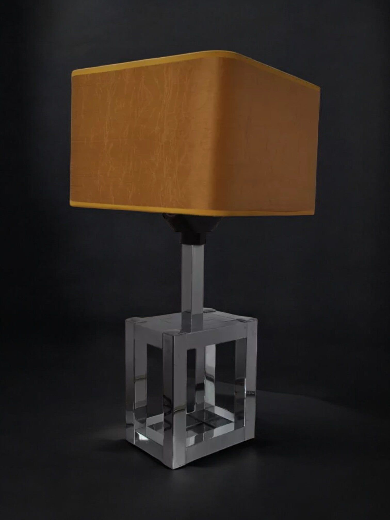 The BD Lumica Cubic Table Lamp by Malamar Studio (Italy, 1970) features a square amber shade and chromed cubic base, making it a striking modern design piece.