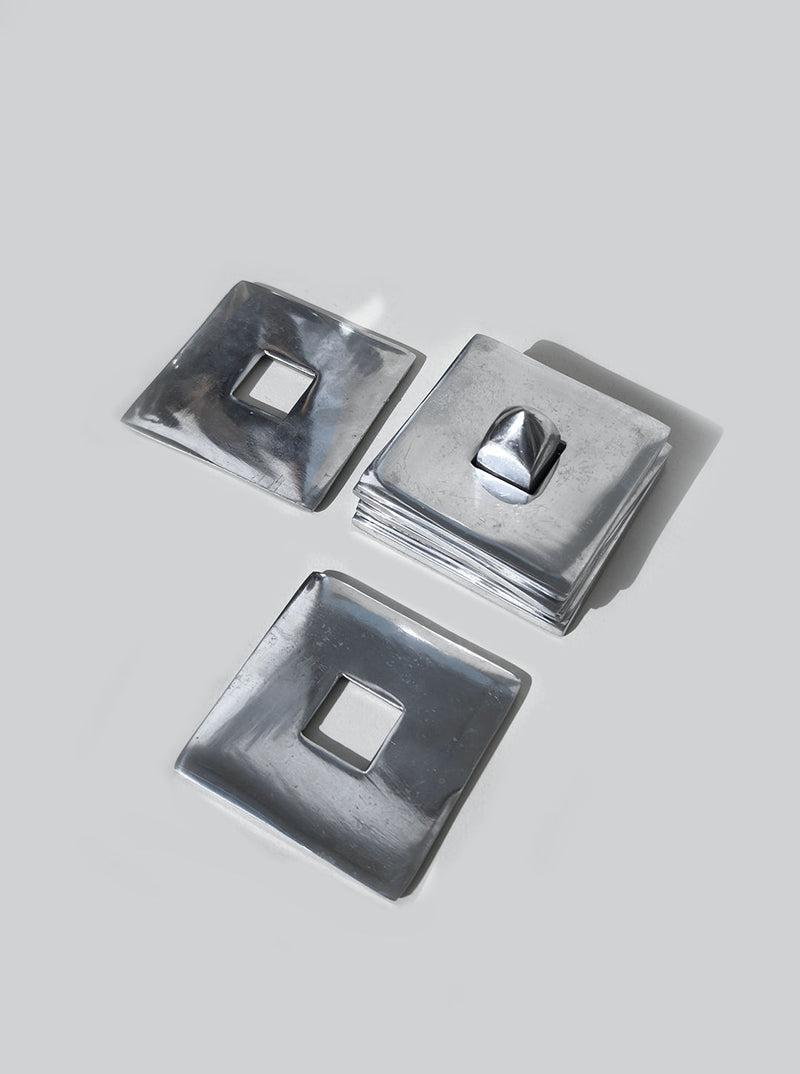 Stacked silver metallic square coasters showing nesting design