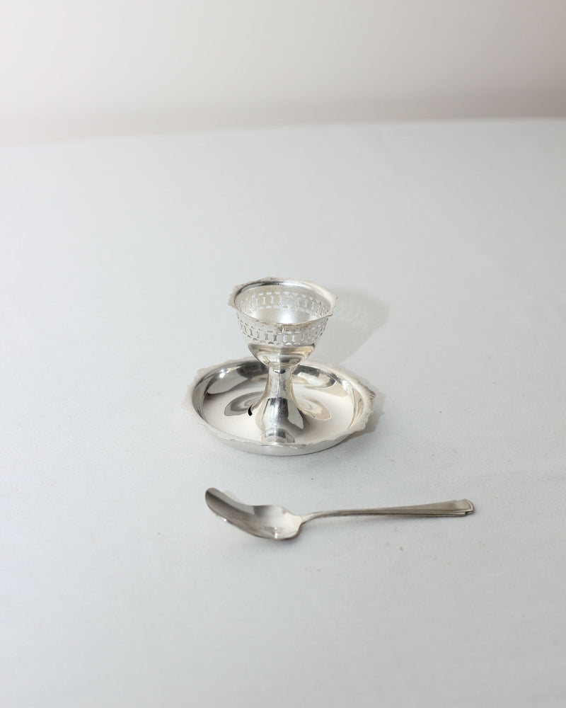 Silver plated egg cup with saucer and spoon on white background