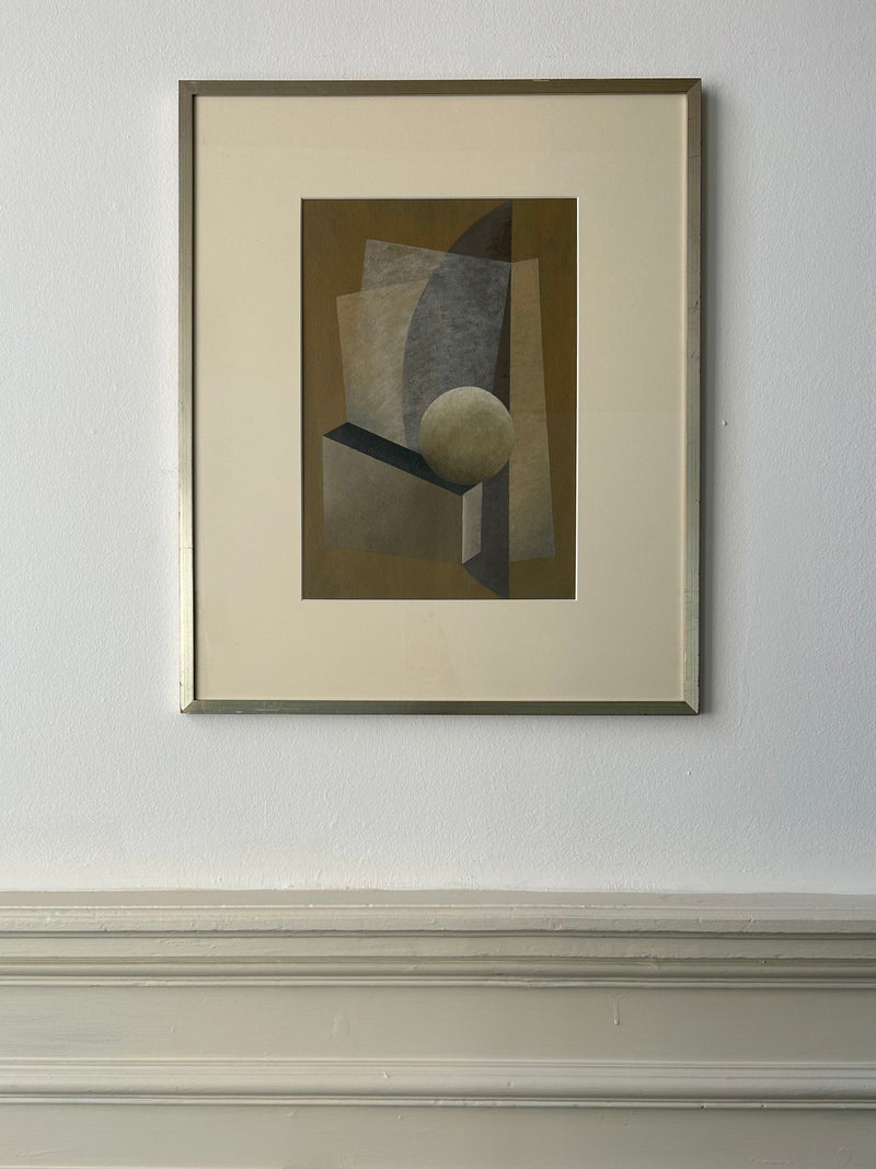 Framed "New Gold Dream" Painting, 2023 by Iris Bavelaar on a white wall, featuring geometric shapes including rectangles and a sphere, in shades of brown, gray, and black. The minimalist composition with light and shadow contrasts is bordered by a vintage frame above paneled wood trim. Dimensions are 50x60cm.