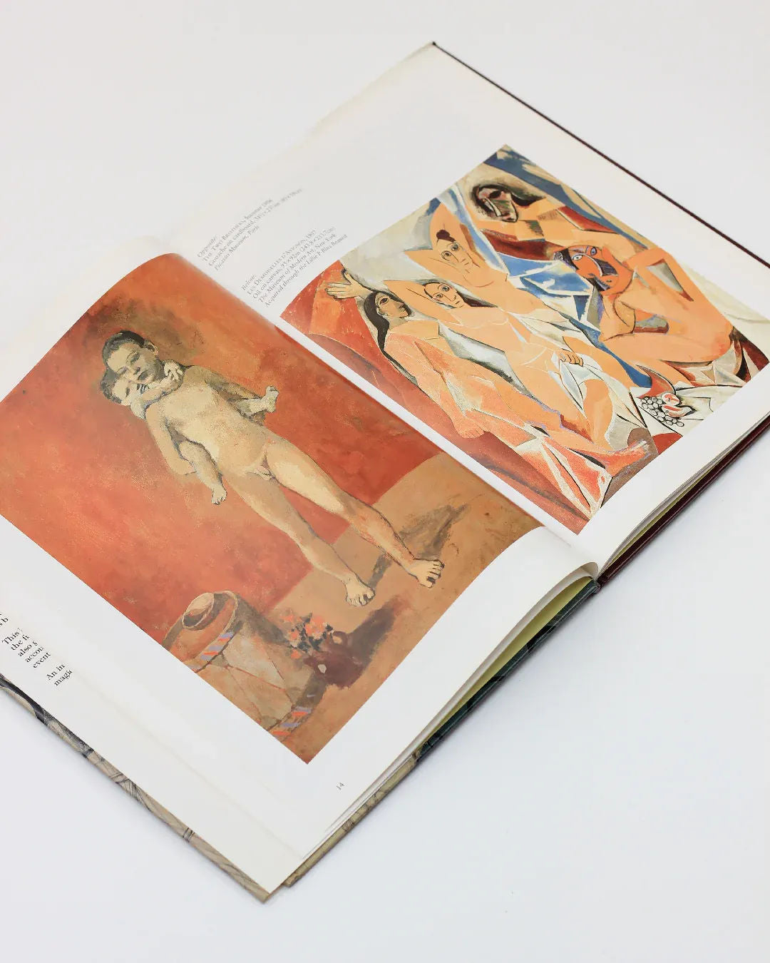 An open copy of the "Picasso by Gabriel Potter Vintage Art Book" from Boga Avante Shop displays two paintings. The left page presents an artwork depicting a child standing beside a pot against an orange backdrop, while the right page features a cubist masterpiece in the style of Picasso, showcasing several abstract human figures by the renowned Spanish artist.