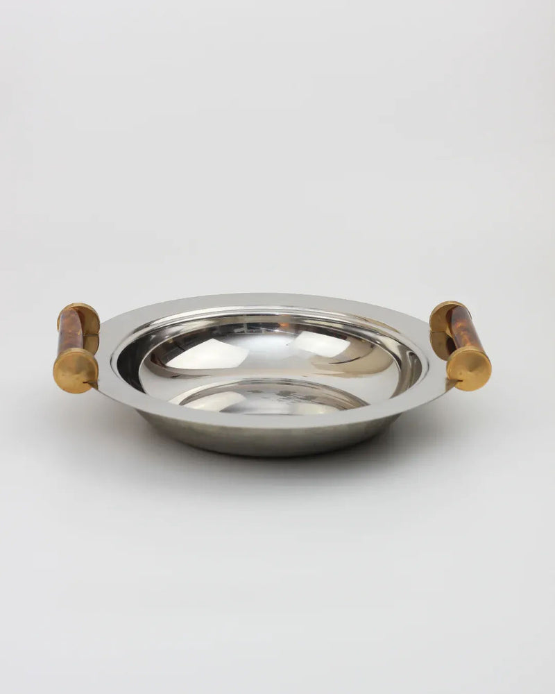 The Boga Avante Shop's Stainless Steel Art-Deco Bowl, shiny and round with enameled handles on each side, sits elegantly on a plain white background.