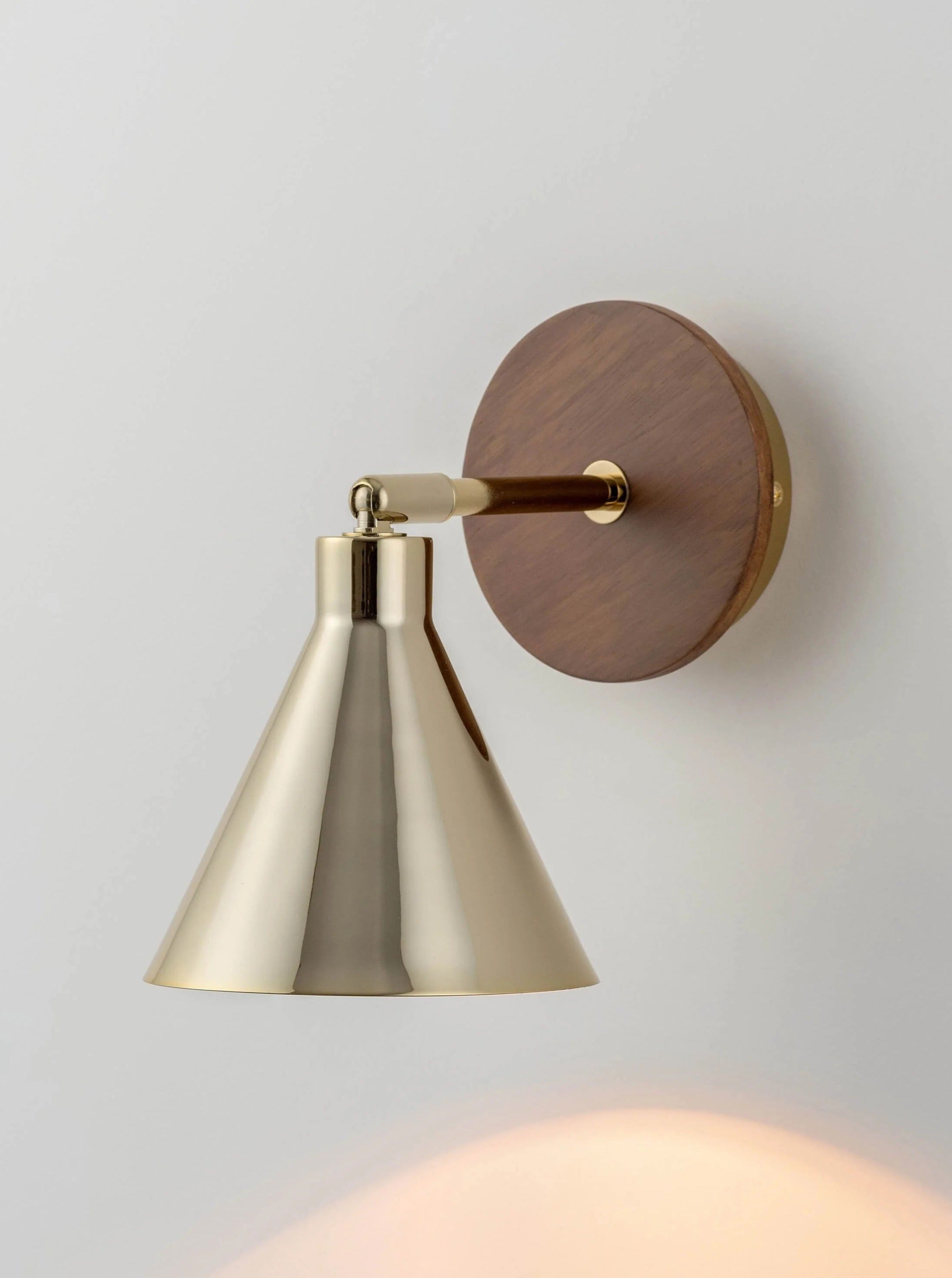 Vintage-inspired brass cone wall light with intricate detailing and warm ambient glow