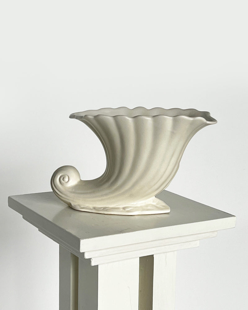 Cream ceramic vase with fluted waves and scalloped rim on pedestal