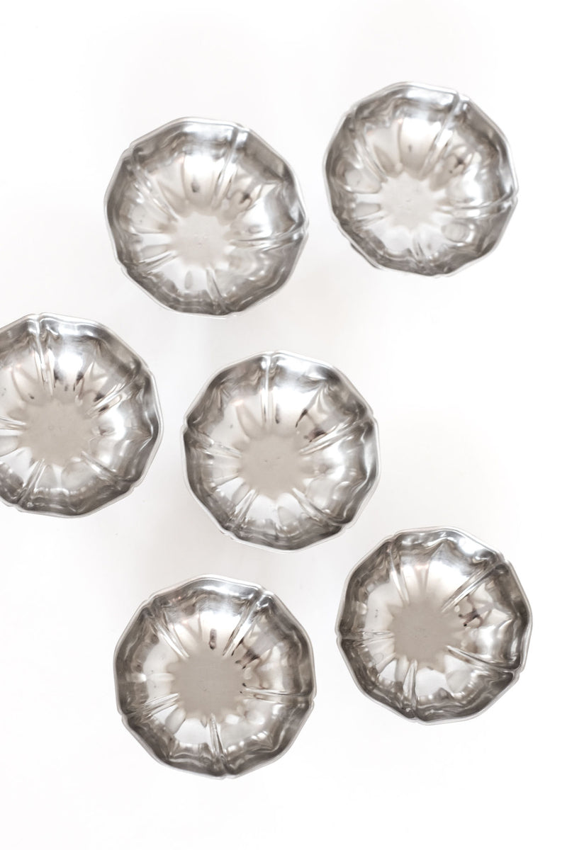 Six crystal ice coupes with fluted design arranged on white surface