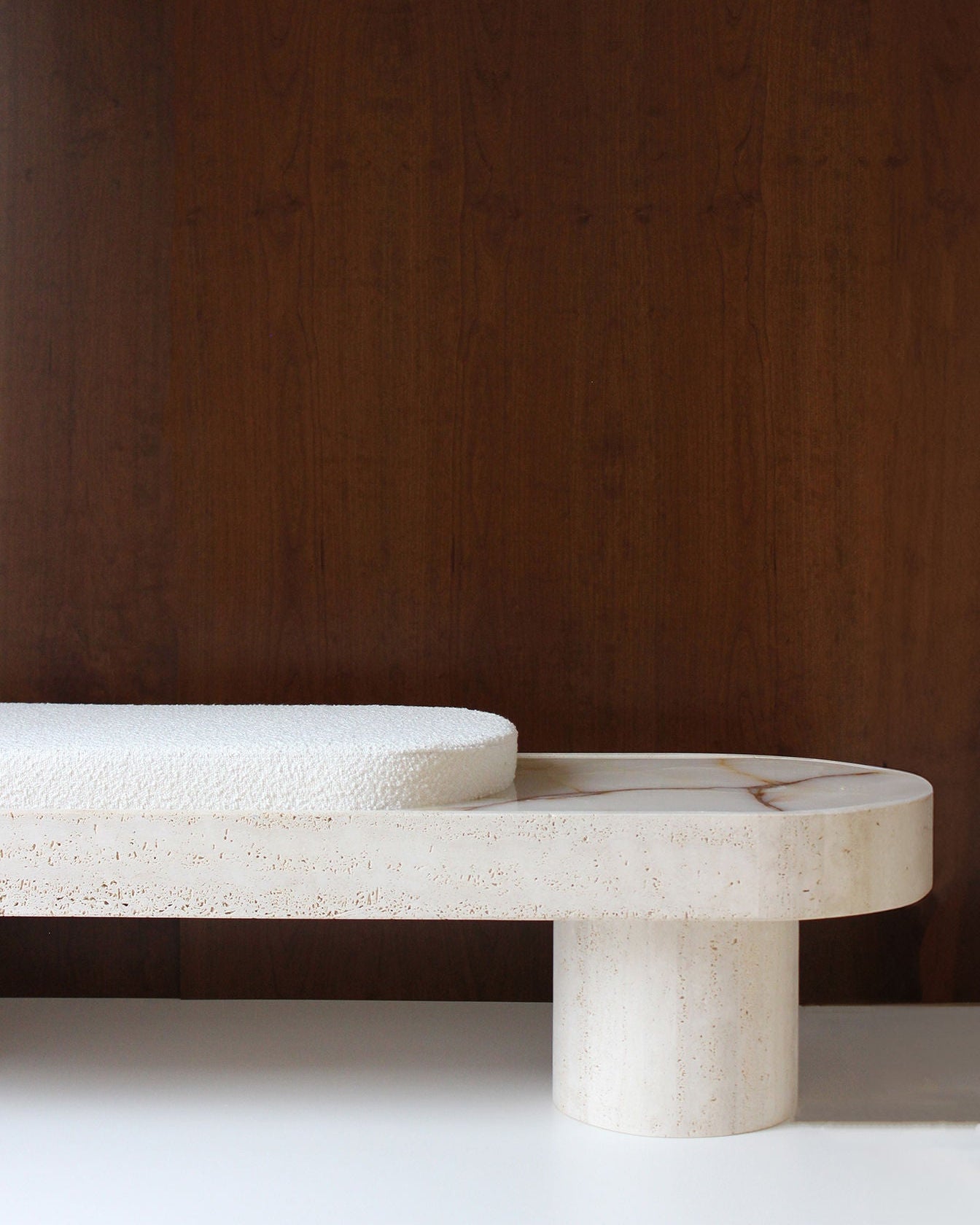 Travertine Noto bench detail showing curved cylindrical leg and textured stone surface