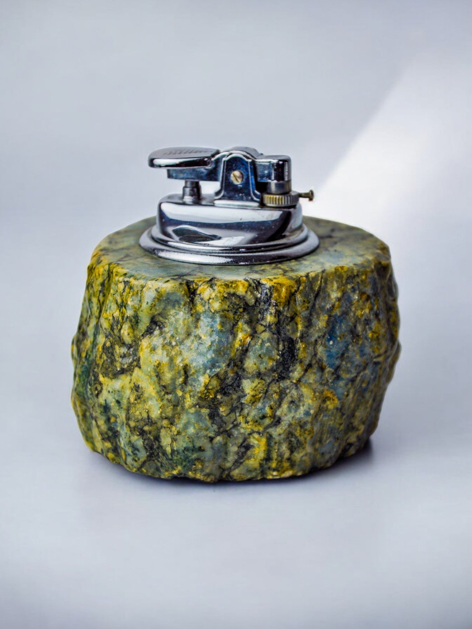 Green alabaster lighter detail showing marbled stone texture and chrome mechanism