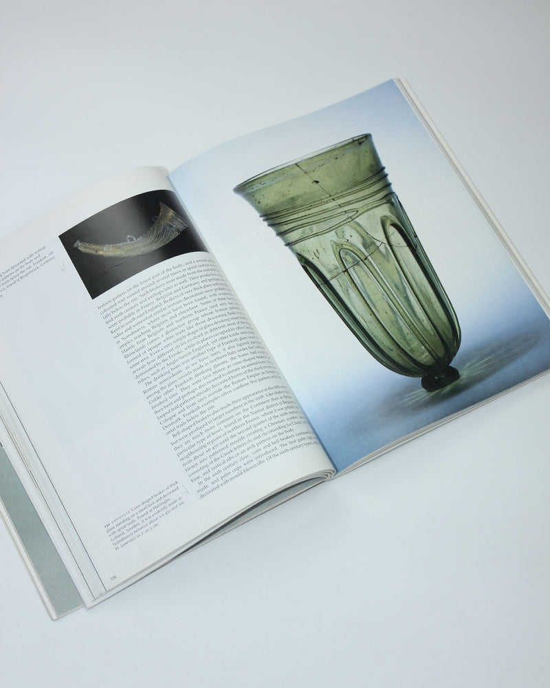 Open glass book displaying antique green goblet and vessel details